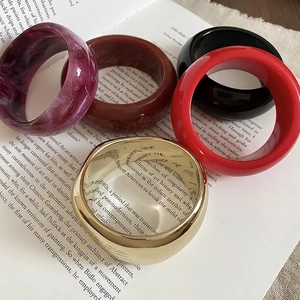 Fashion resin marble and gold metal geometric wide bangles stacked on vintage book