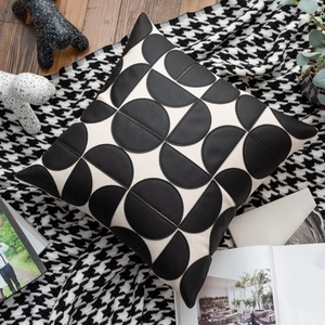 Detail of a square cushion cover featuring black and white geometric semi-circle patterns