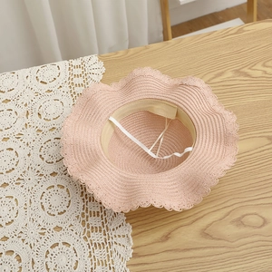 Detail of pink girls straw hat showing wave brim, inner sweatband and adjustable drawstring
