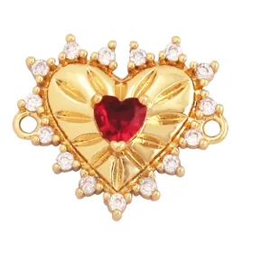 Macro detail of heart shaped gold plated connector with red crystal and white rhinestones