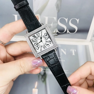 Vista macro de un reloj cuadrado plateado con diamantes y números grandes de estilo art deco