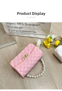 Pink quilted silicone jelly bag with faux pearl handle and gold clasp on wooden floor