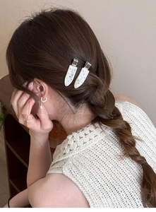 Close-up of elegant water drop hair clip with colorful rhinestones on a braided hairstyle