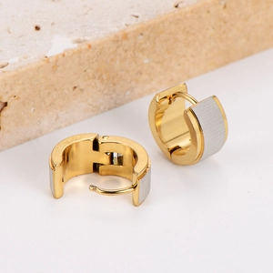 Detail of gold and silver two-tone stainless steel hoop earrings with brushed finish