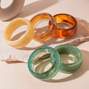 Chic vintage acrylic striped bangle set in amber and marble tones on stone pedestal