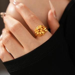 Detailed macro view of 24k gold-plated floral cluster ring on model's hand
