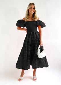 Detail of black plaid off-shoulder dress with puff sleeves and white knot handbag accessory