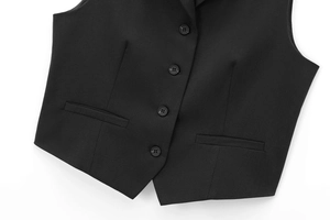 Detail of black waistcoat featuring four-button closure and classic welt pockets