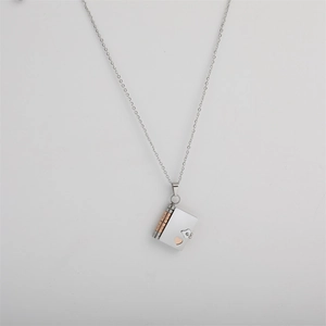 Detailed view of silver titanium steel book pendant necklace with gold heart design