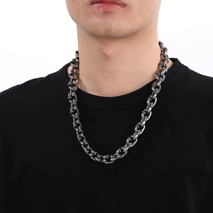 Close-up of a chunky silver stainless steel Cuban link necklace worn by a male model
