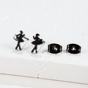 Detailed close-up of matte black ballet dancer silhouette earrings on a white stone base