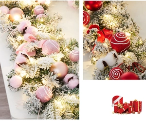 Détail de la guirlande en PE enneigé avec ornements roses, boules de coton et LED