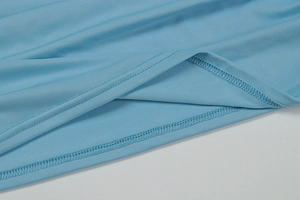 Detailed close-up of light blue dress hem featuring precise double-needle stitching quality
