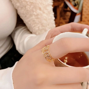 Bague géométrique ajourée en argent S925 doré portée dans un décor de style de vie
