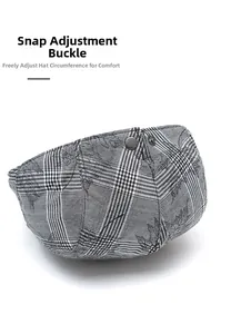Detail of adjustable metal buckle on gray plaid beret cap with maple leaf pattern