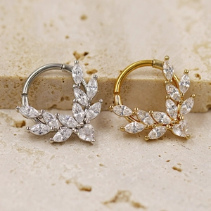 Macro detail of leaf-shaped nose rings with marquise cubic zirconia in gold and silver