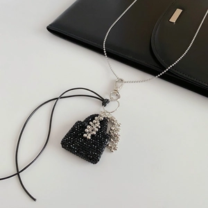 Détail d'un chic charms de sac à main perlé noir avec chaîne en argent élégante
