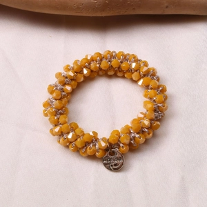 Detailed macro shot of yellow faceted crystal beaded bracelet with silver Morana charm