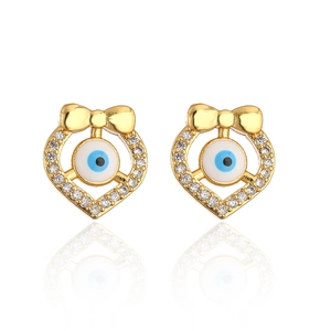 Macro detail of 18K gold plated evil eye stud earrings with crystals and bowknot motifs