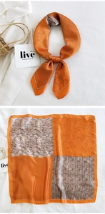 Detail of a square silk scarf with orange and brown floral patterns and polka dots