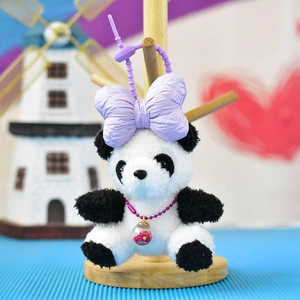 Close-up of cute panda plush toy with purple bow and sparkling star necklace