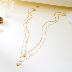 Close-up of double-layer gold necklace with pink starfish, seashell and pearl charms