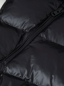 Macro shot of high-quality zipper on glossy black puffer jacket with waterproof texture