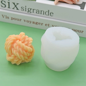 Knitted yarn ball silicone mold for DIY candles, soap and cake baking on green background
