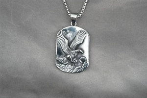 Macro shot of silver cobra military pendant with eagle relief on box chain necklace