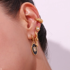 Detailed close-up of 18K gold plated liquid hoop earrings and black oval stud set