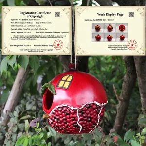 Hanging red pomegranate birdhouse resin garden ornament outdoors on tree branch