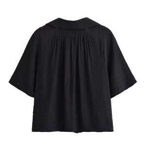 Detail of the pleated back and crisp collar on this black short-sleeve textured jacket