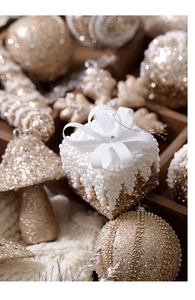 Close-up of white gift box ornament with pearl beads and ribbon on Christmas tree