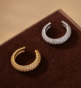 Detailed close-up of gold and silver ear cuffs with pavé-set shimmering cubic zirconia