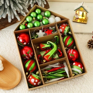 Detail of red and green Christmas ornaments set in a decorative house-shaped box