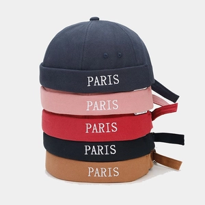 Vertical stack of canvas docker hats in multiple colors featuring white PARIS embroidery