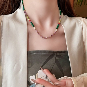 Detailed view of colorful beads necklace with gold spacers worn on a model neckline
