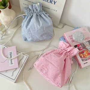 Dettaglio di borse a secchiello rosa e azzurre con stelle d'argento e catene di perle