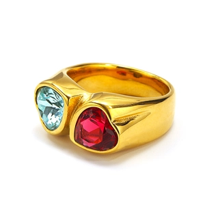 Macro view of double heart-shaped blue and red gemstones set in a gold band