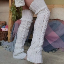 Detailed macro shot of white cable-knit leg warmers with a cozy woolen texture