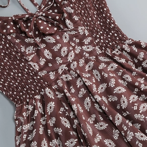 Detailed view of the smocked bodice and daisy floral print on a brown vintage dress