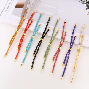 Detail of adjustable woven cord bracelets in various colors with gold sliding metal clasps