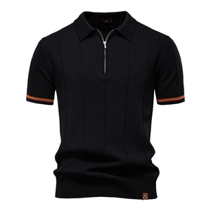 Dettaglio polo in maglia nera con bordo arancione sul polsino e colletto con zip