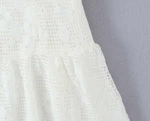 Gros plan sur un tissu en dentelle blanche avec broderie florale ajourée haute densité