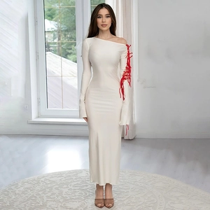 White one-shoulder long sleeve maxi dress with red lace-up detail and side slit