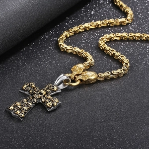 Close-up of titanium steel cross skull pendant on textured black backdrop