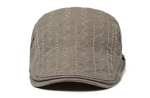 Detailed view of olive canvas beret hat featuring white wavy decorative stitching