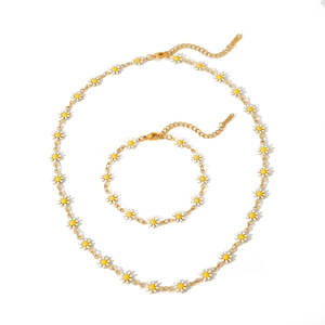 Set dettagliato di collana e bracciale a catena con margherite in acciaio inox dorato su bianco