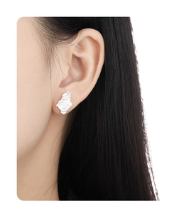 Close-up of asymmetrical S925 sterling silver earrings with textured crinkle surface