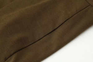 Détail de la couture et de la texture tissée du pantalon large décontracté marron